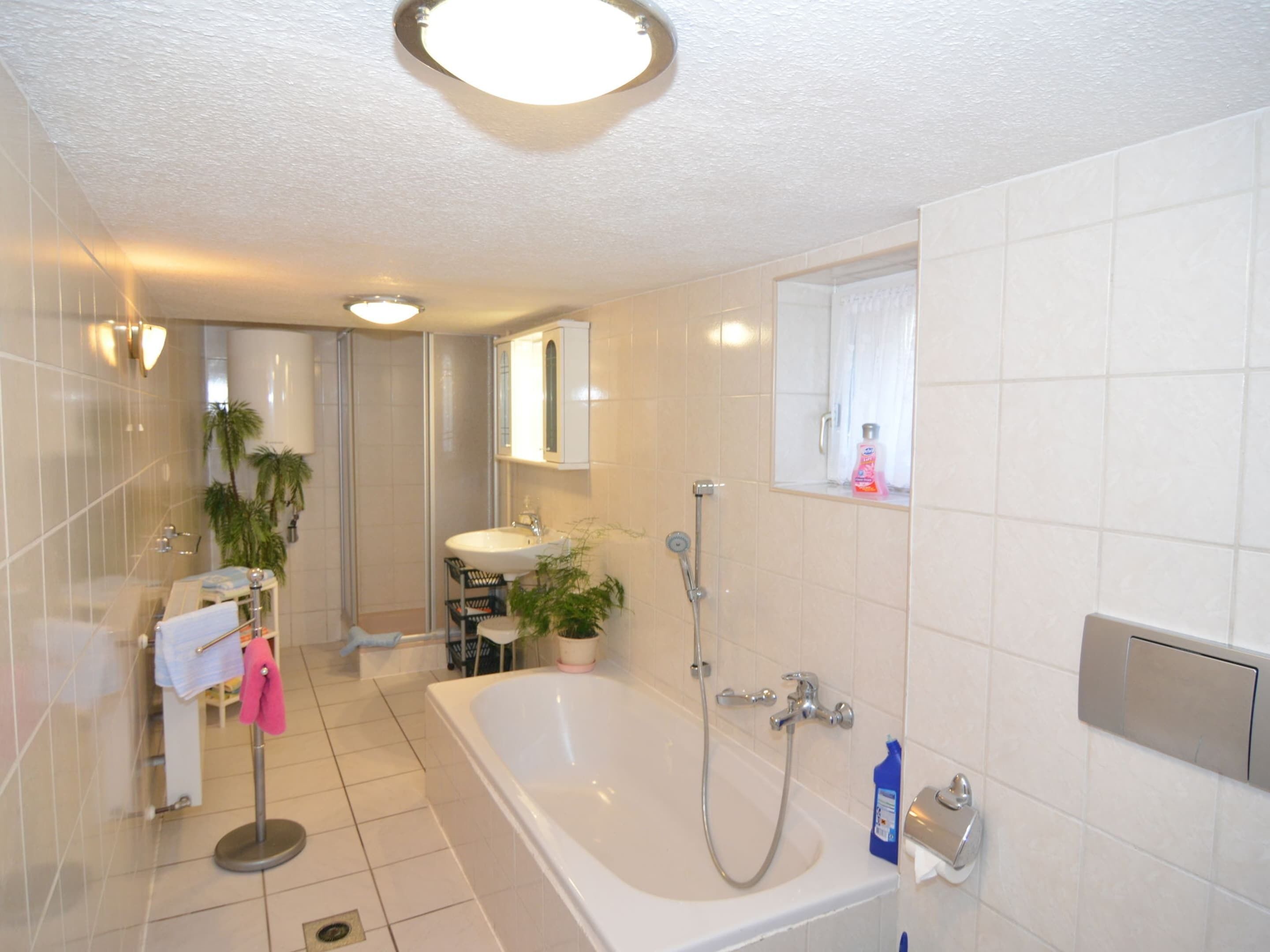 Une salle de bain moderne équipée d’une baignoire, d’une douche et d’un lavabo.