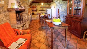 A rustic interior with a stone fireplace, wooden furniture, and a tiled floor. - Alluring Farmhouse in Ortignano With Swimming Pool (Ortignano Raggiolo)