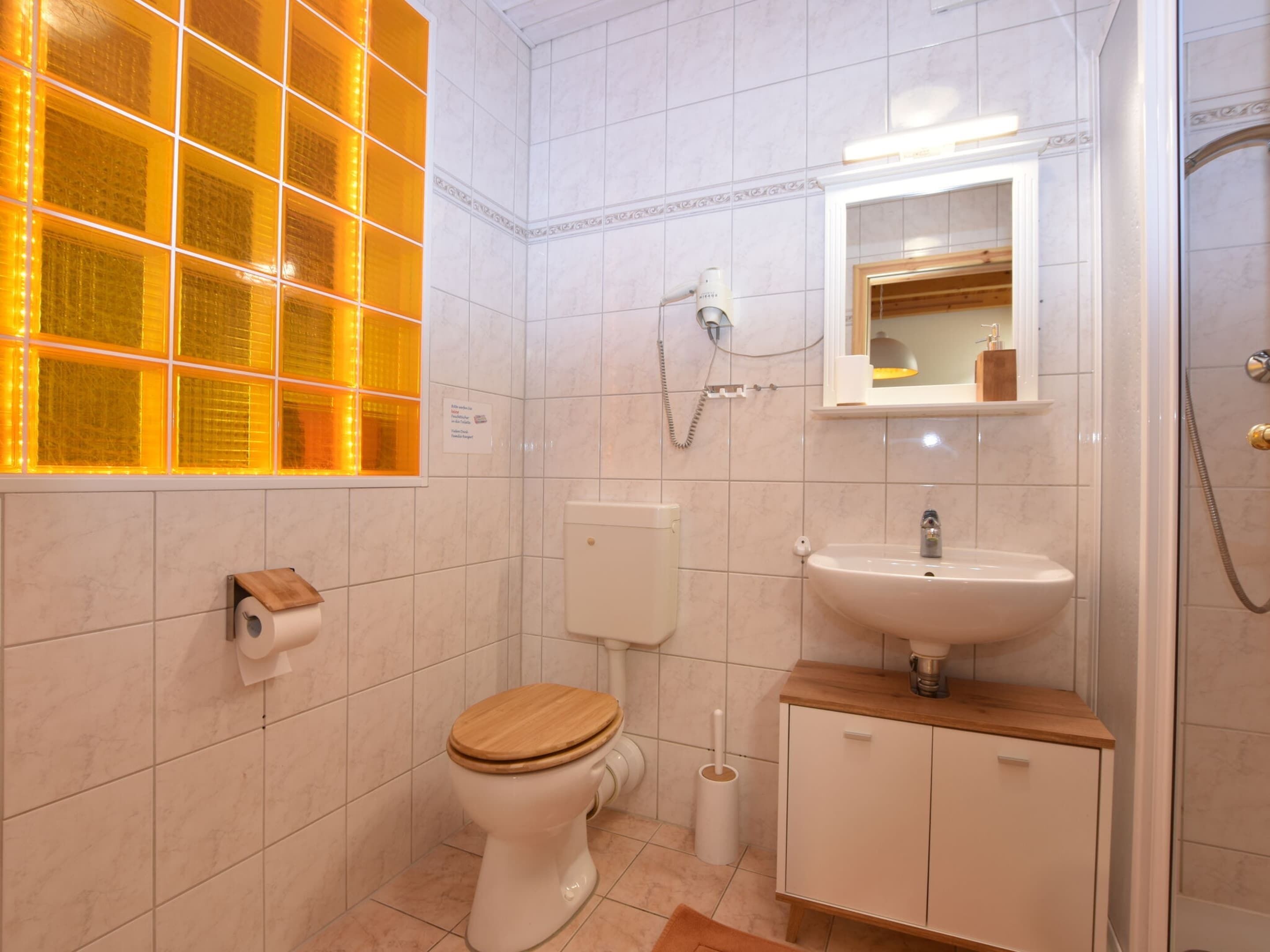 A modern bathroom with a toilet, sink, and shower.