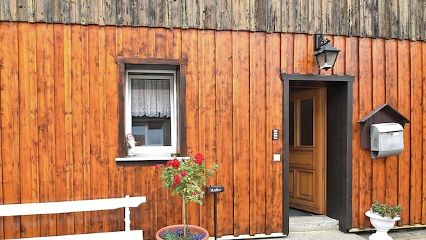 A wooden building with a bench, a potted plant, a mailbox, and a door. - Nice Apartment in Allrode With Private Terrace (Thale)