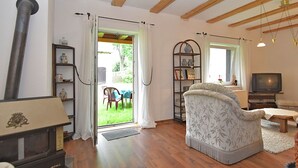 A living room with a fireplace, a television, and a view of the outdoors. - Nice Apartment in Allrode With Private Terrace (Thale)