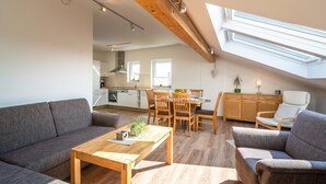A modern loft apartment with a dining area, kitchen, and a large window providing natural light. - Dreamy Holiday Home in Ellscheid With Terrace (Ellscheid)