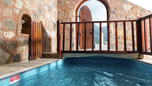 A stone-walled pool area with a wooden gate and a clear water depth marker. - Elounda-bay View Greek Apartment With Private Terrace (Agios Nikolaos)