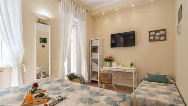 Une chambre d’hôtel avec un lit, un bureau, une chaise et un téléviseur.