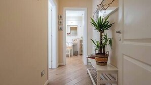 Un couloir étroit, doté d’un plancher en bois, mène à une cuisine.