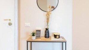 A small console table with a potted plant, a decorative item, and a candle.