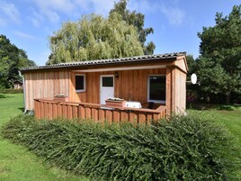 Eine Holzhütte mit Veranda, kleinem Fenster und Tür.