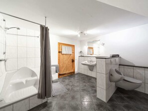 Une salle de bain moderne équipée d’une baignoire, d’une douche et de toilettes.