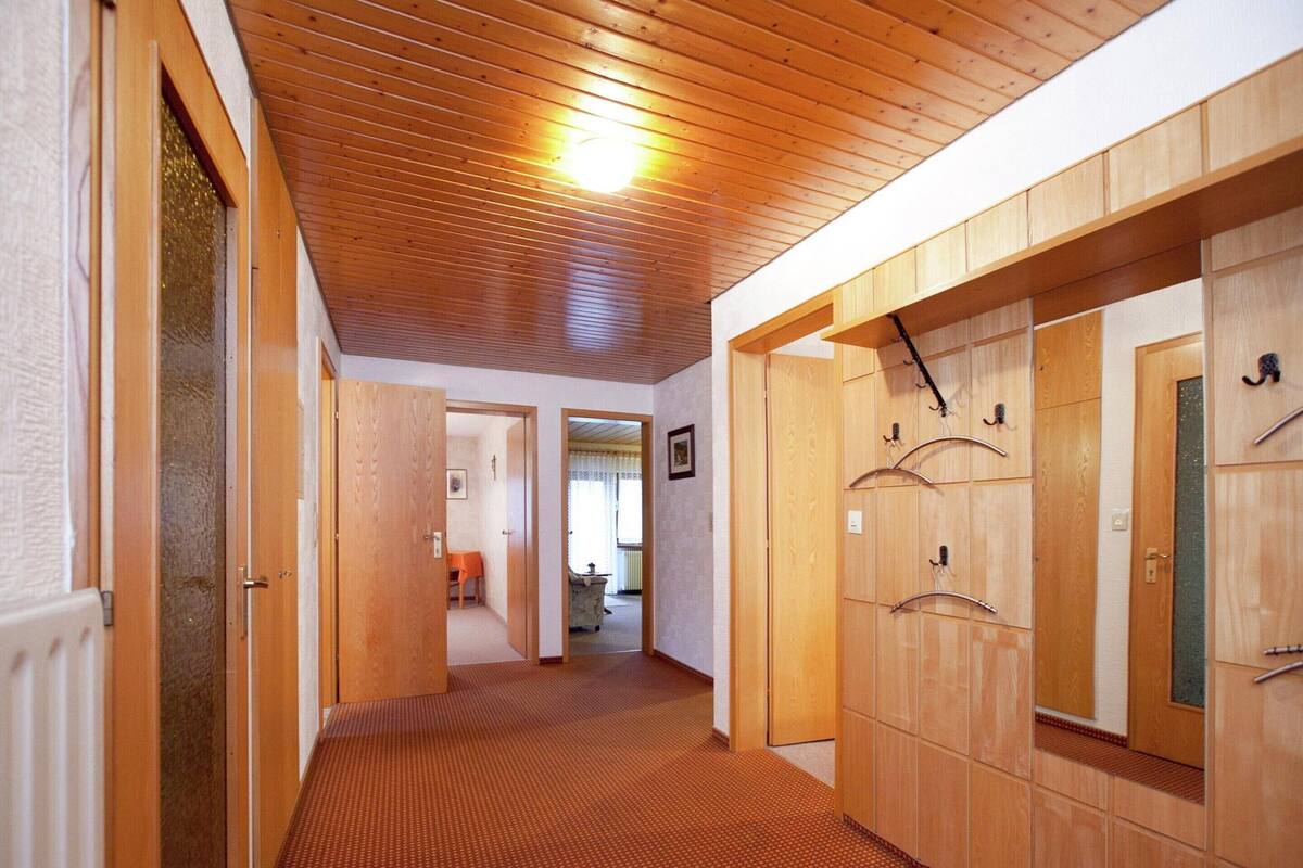 A corridor with wooden lockers and a carpeted floor.