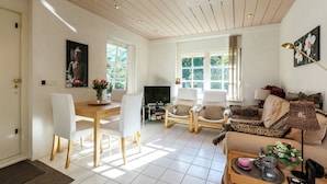 A spacious living room with a dining area, a sofa set, and a television. - Quaint Apartment in Oostkapelle Zealand With Terrace (Oostkapelle)