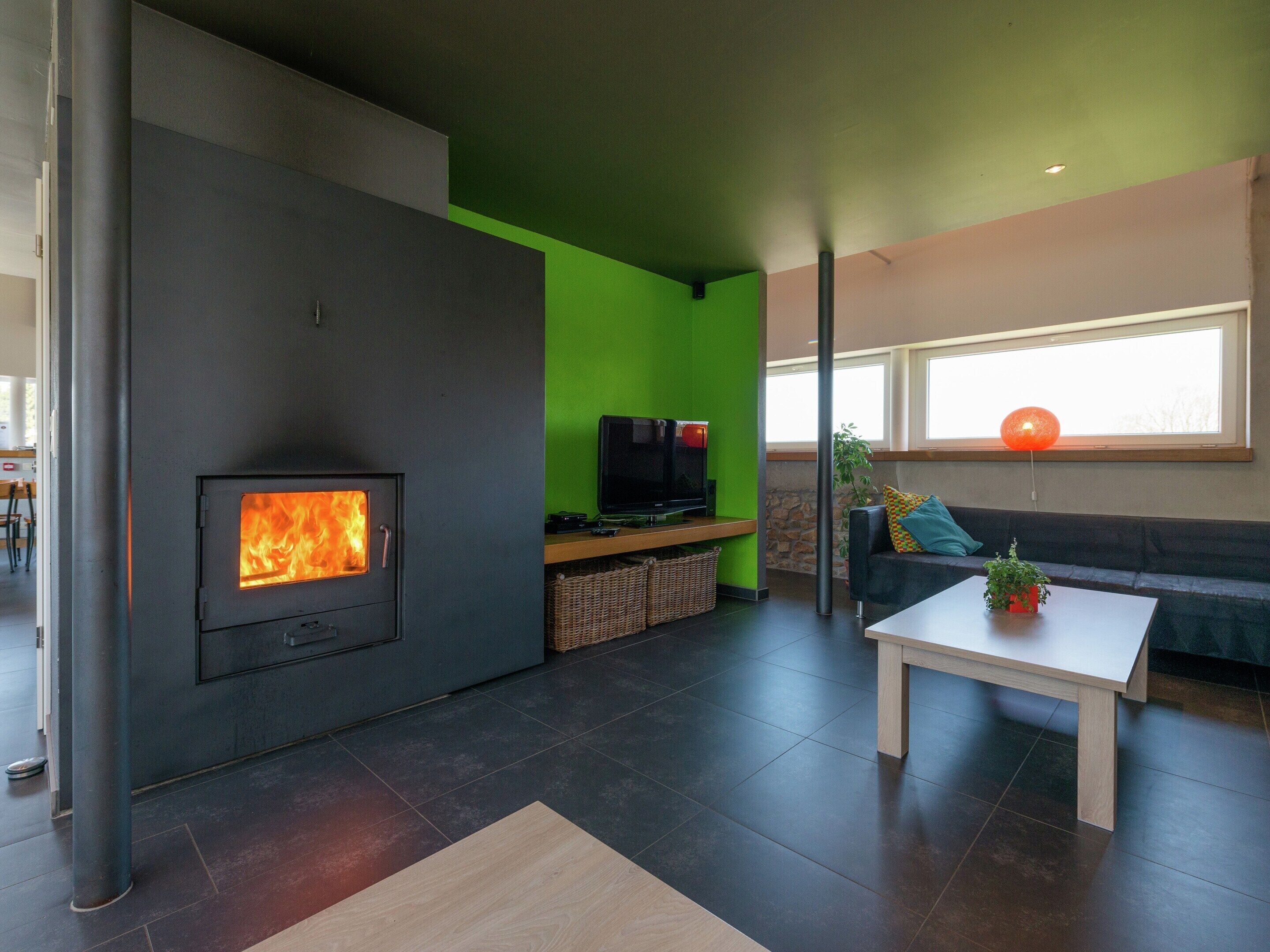 A modern living room with a fireplace, a television, a sofa, and a coffee table.