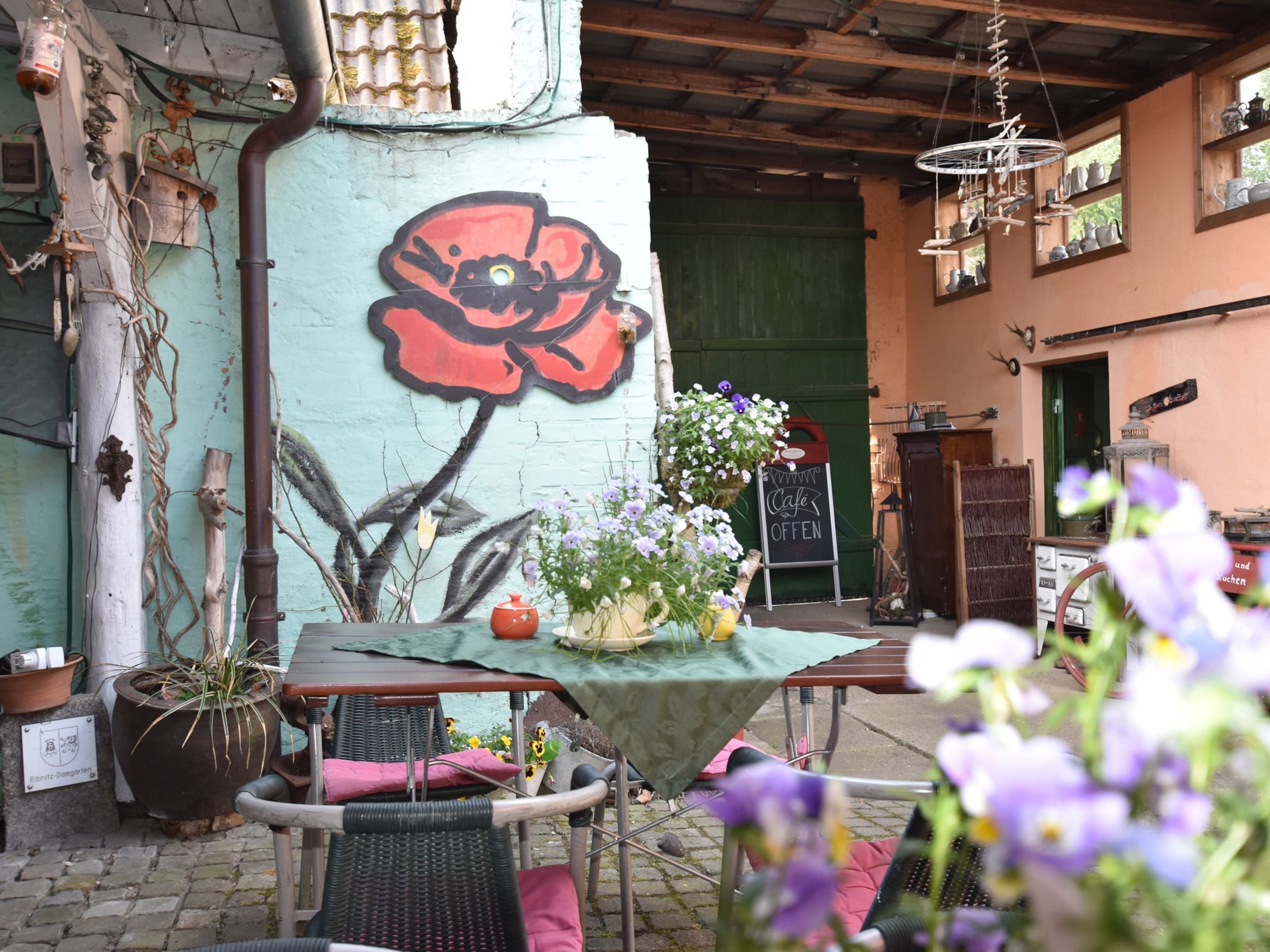 An outdoor seating area with a table, chairs, and potted plants.