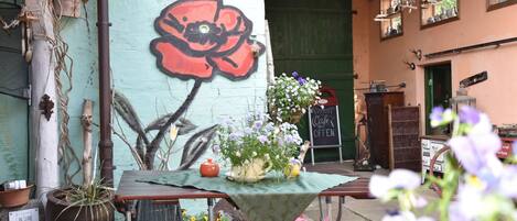 An outdoor seating area with a table, chairs, and potted plants.