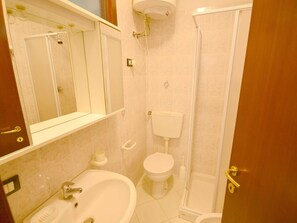 Un baño con lavamanos, inodoro y ducha.