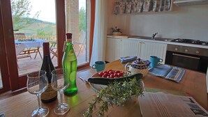 Un tavolo da pranzo con bicchieri da vino, una bottiglia, una ciotola di frutta e un menu.