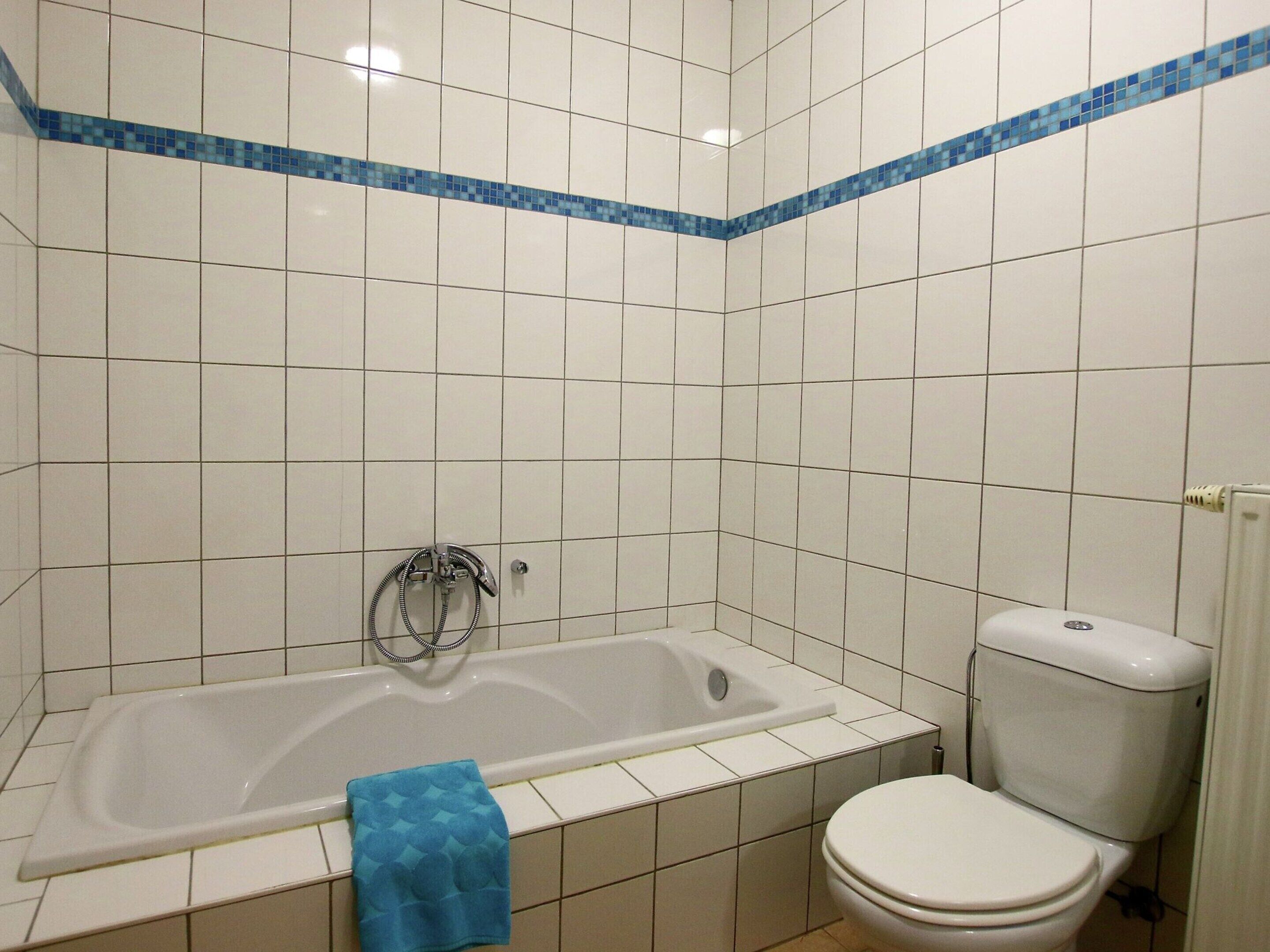 Une salle de bain avec une baignoire, des toilettes et un porte-serviettes.