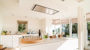 A modern kitchen with a large island, built-in appliances, and a view of the outdoors. - Luxurious Villa With Pool and Sauna, and Very Suitable for Culinary Workshops! (Waimes)