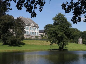 A large, historic building with a symmetrical facade, a prominent central entrance, and a small tower. - Luxurious Castle in Marchin With Infrared Sauna (Marchin)