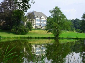 A large, historic building with a symmetrical facade, a central entrance, and a well-maintained lawn. - Luxurious Castle in Marchin With Infrared Sauna (Marchin)