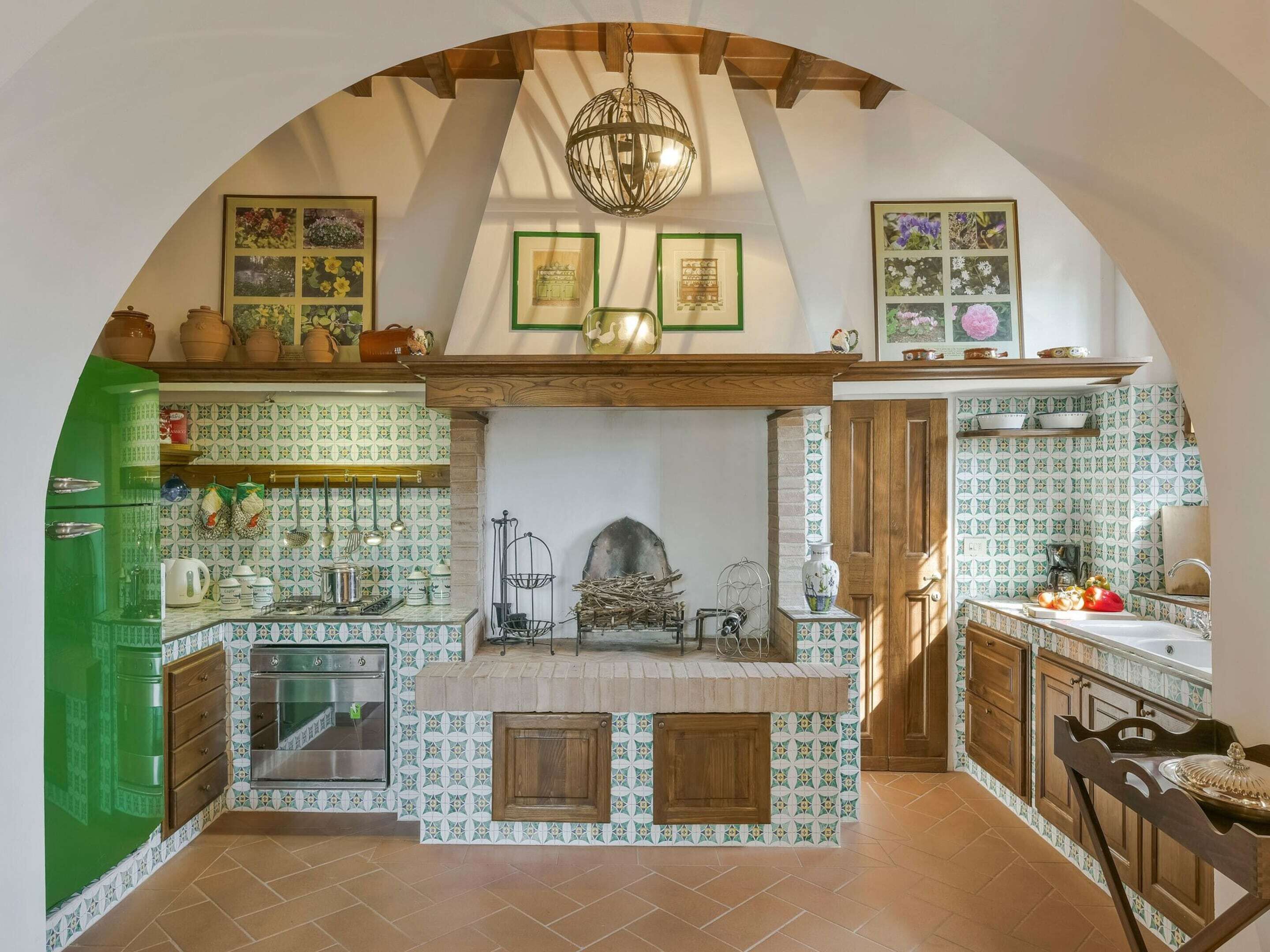 A kitchen with a tiled backsplash, wooden cabinets, a built-in oven, and a hanging light fixture.