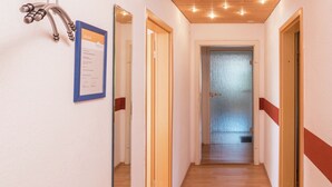 A hallway with wooden floors and doors, a framed certificate on the wall, and a wooden ceiling with recessed lighting. - Cozy Apartment in Schwenningen With Garden (Villingen-Schwenningen)