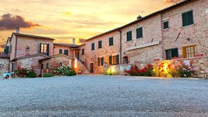 A courtyard with stone buildings, a staircase, and flower beds. - Lovely Farmhouse in Asciano With Swimming Pool (Asciano)