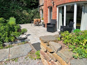 A patio with stone flooring, outdoor furniture, and a brick building with large windows. - Suave Holiday Home in Stavelot With Infrared Sauna (Stavelot)