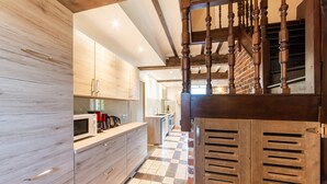 Una cocina moderna con armarios de madera, piso a cuadros y una escalera con barandillas de madera.