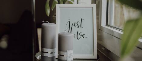 A framed sign with the text "Just love" and two candles on a tray.