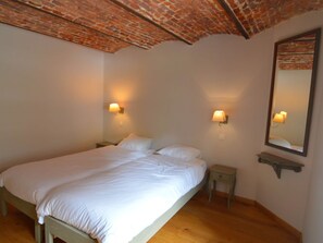 A bedroom with a large bed, two bedside tables, a nightstand, a wall-mounted shelf, and a mirror. - Gite With Swimming Pool Situated in Wonderful Castle Grounds in Gesves (Gesves)