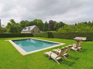 A rectangular swimming pool with a wooden deck and lounge chairs in a well-maintained lawn area. - Gite With Swimming Pool Situated in Wonderful Castle Grounds in Gesves (Gesves)