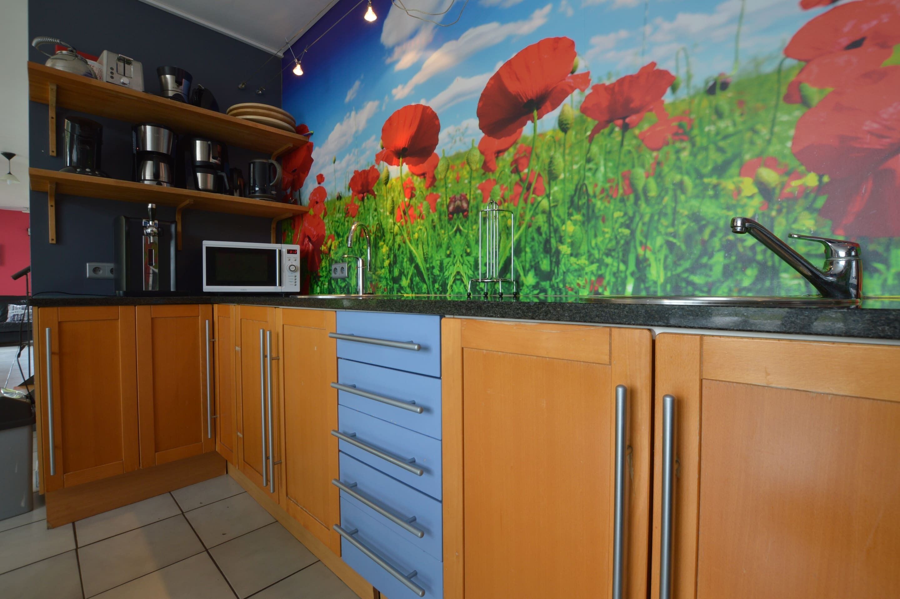 A kitchen with wooden cabinets, a microwave, and a sink.