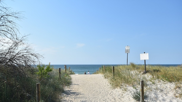 A sandy beach path with wooden posts and signs, leading to the ocean. - Rustic-style Apartment in Buschenhagen With Garden (Niepars)