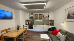 A modern kitchen with white cabinets, a stainless steel range hood, and a built-in oven. - Central Apartment With Balcony, Terrace, Garden, Deckchairs (Brixen im Thale)