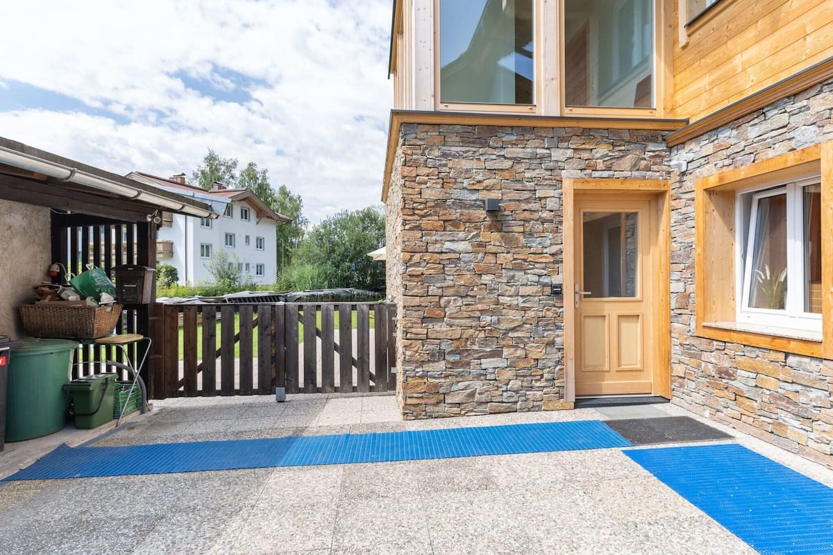 A building with a stone facade, a wooden door, and a blue mat on the ground.