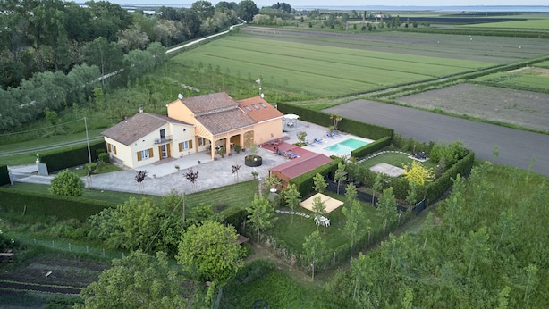 A large house with a swimming pool, surrounded by well-maintained gardens and fields. - Holiday Countryside Home With Swimming Pool, Sauna. Less Than 20km From the sea (Codevigo)