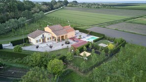 A large house with a swimming pool, surrounded by well-maintained gardens and fields. - Holiday Countryside Home With Swimming Pool, Sauna. Less Than 20km From the sea (Codevigo)