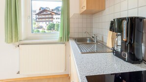 A kitchen with a window, a sink, a coffee maker, and a view of a building outside. - Inviting Holiday Apartment in Ladis With Balcony (Ladis)