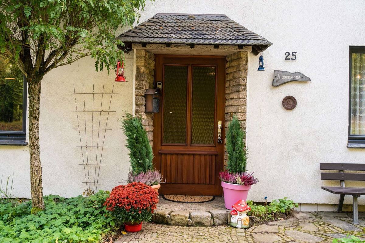 A house with a stone facade, a wooden door, and a number '25' on the wall.