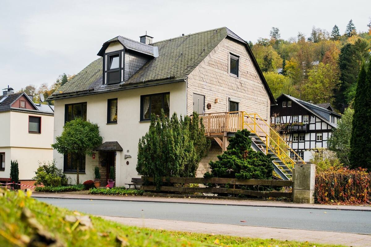 A two-story house with a balcony and a staircase leading to the upper floor.
