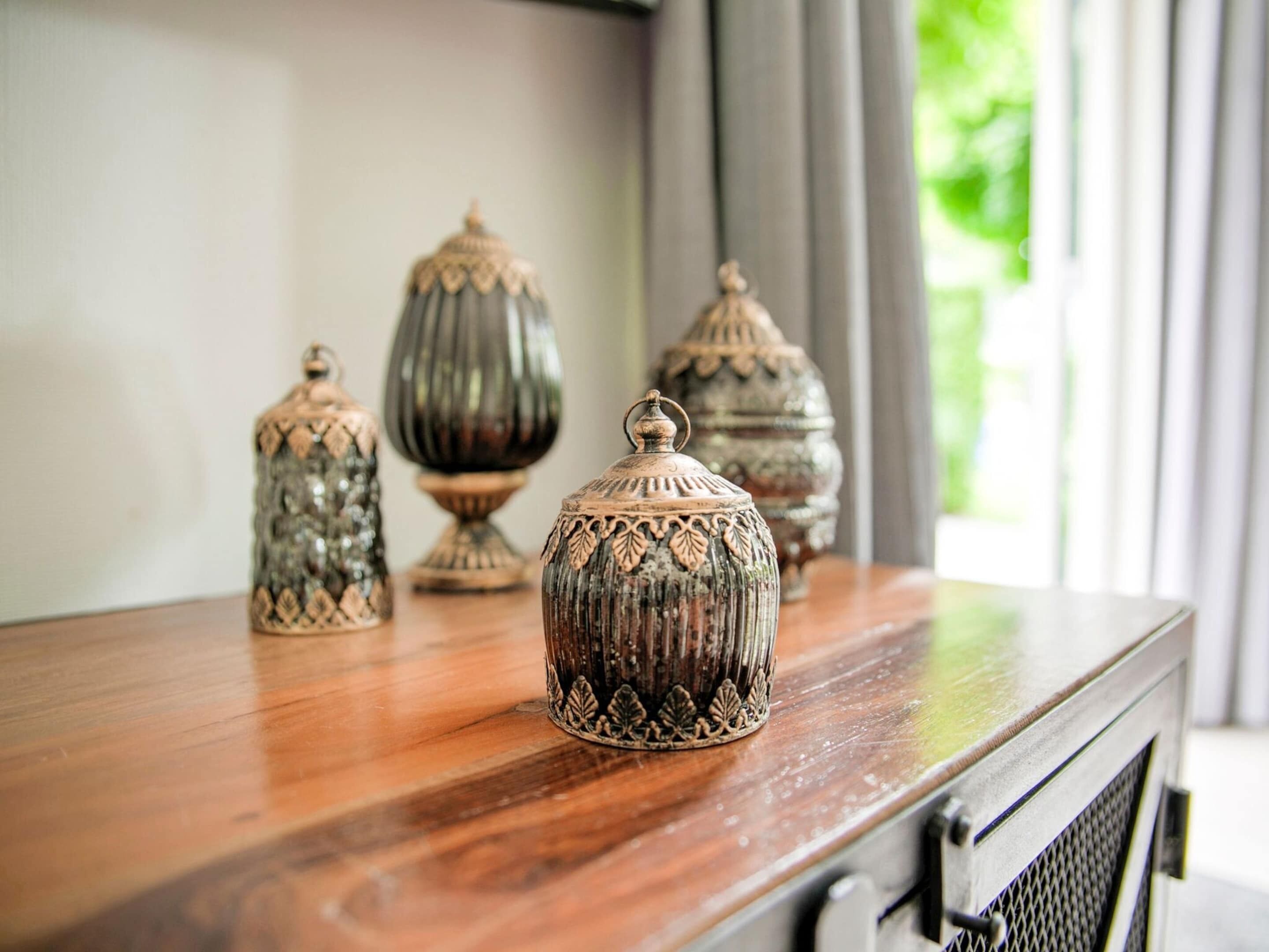 Een houten tafel met versierde keramieken potten.