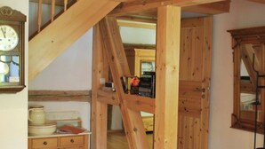 A wooden staircase leading to a loft bedroom with a wooden ceiling and a window. - Chic Apartment in Thuringia With Sauna (Heringen)