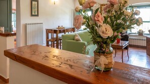 A wooden table with a vase of flowers in a rustic setting. - Appealing Apartment in Collesalvetti With Garden (Collesalvetti)