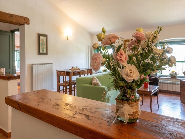 A wooden table with a vase of flowers in a rustic setting. - Appealing Apartment in Collesalvetti With Garden (Collesalvetti)