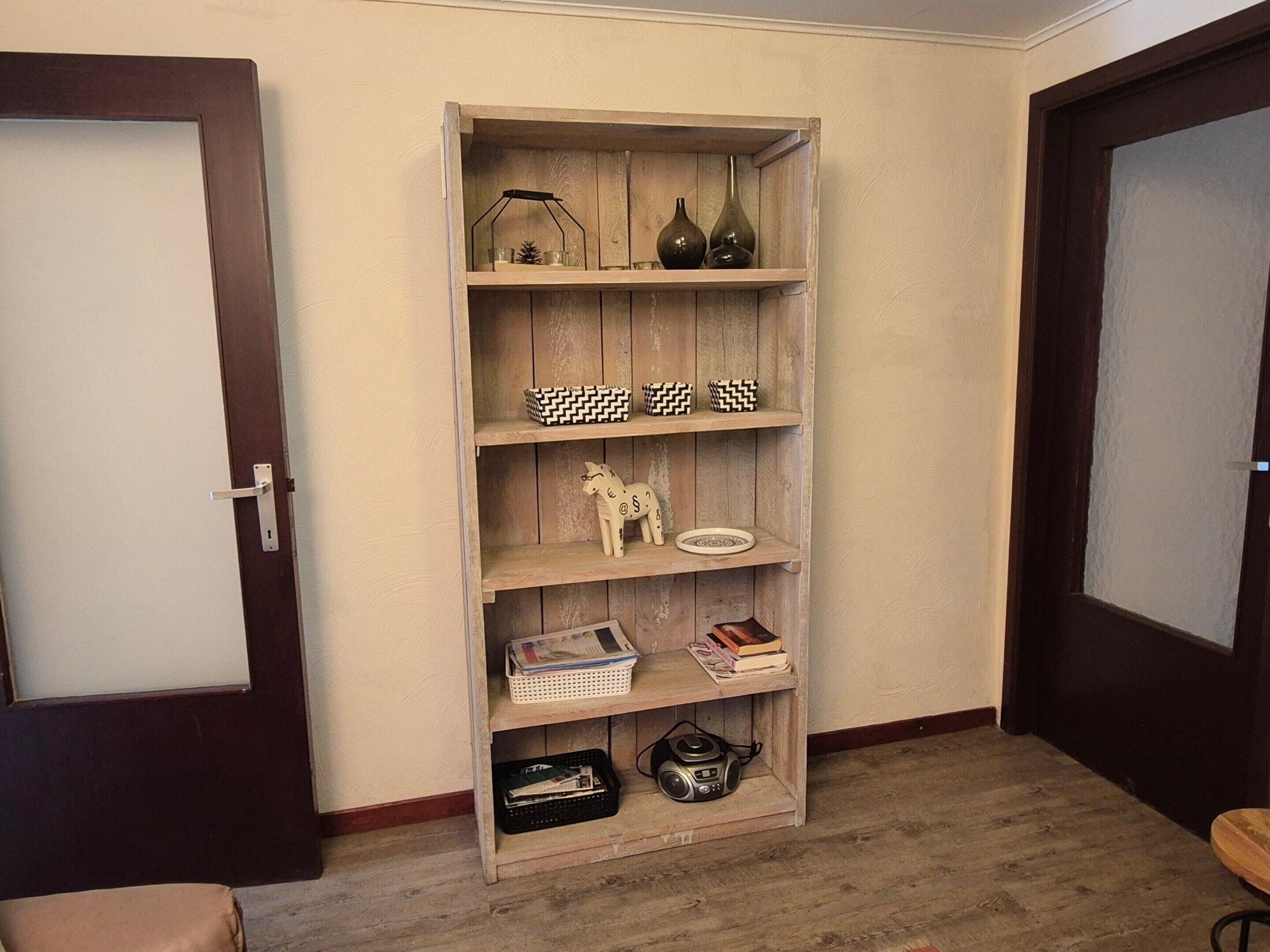 A wooden bookshelf with decorative items and a small figurine.