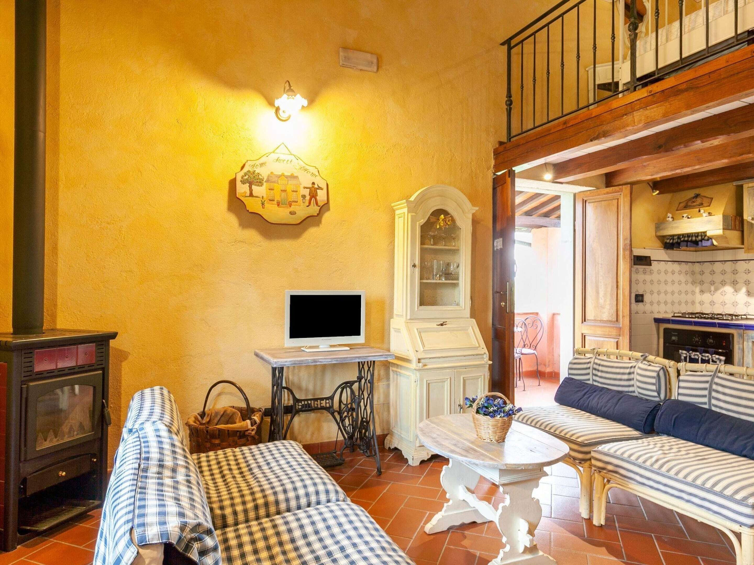 A cozy living room with a fireplace, a television, a dining table, and a sofa set.