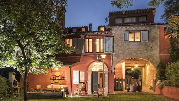 A two-story building with an arched entrance, a small garden, and outdoor seating. - Spacious Villa With Pool in Fabriano Italy (Fabriano)