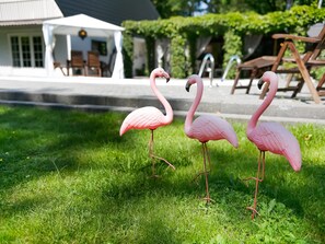 Enjoy a serene outdoor setting with a tranquil atmosphere, surrounded by lush greenery and a well-manicured lawn.