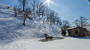 Ett snötäckt landskap med en timmerstuga och träd.