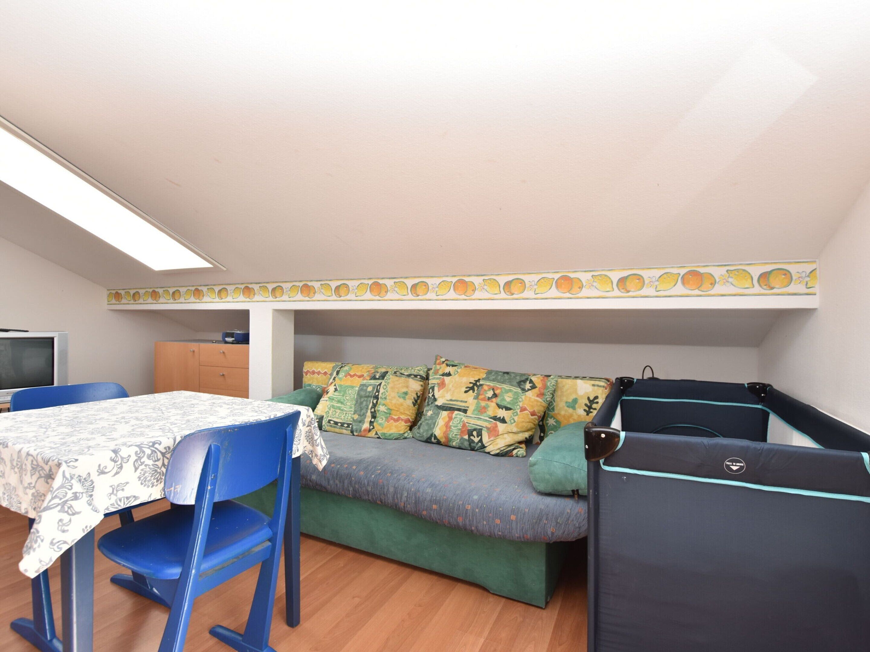 Una habitación pequeña con sofá, una mesita y una silla.